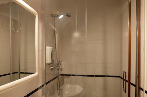 baño con ducha y puerta de cristal en Casas da Avó Alsira, en Évora