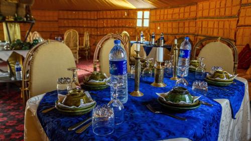 un tavolo con una tovaglia blu e bottiglie sopra di Atta Desert Camp a El Gouera