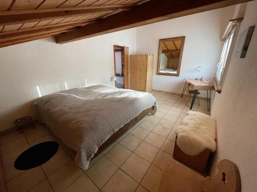 a bedroom with a bed and a table and a mirror at Appart sympa ! in Sonceboz