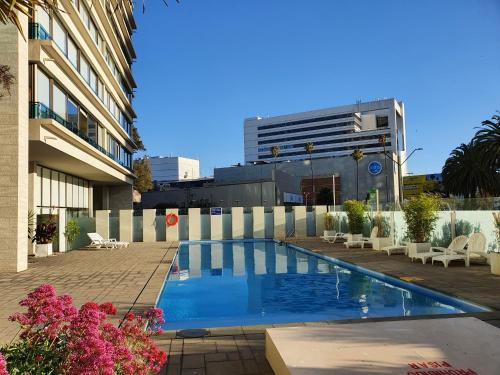 una piscina al lado de un edificio en Apartamento Deluxe Edificio Torremar, frente al Mall Marina Arauco, en Viña del Mar