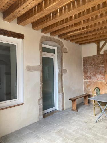a patio with a table and a window and a bench at Appart' Au Coeur de Nuits in Nuits-Saint-Georges