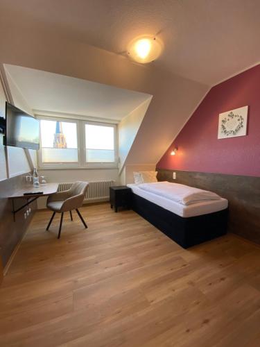 - une chambre avec un lit, un bureau et une chaise dans l'établissement Hotel Schütz, à Trèves