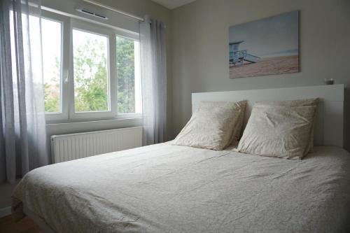 - une chambre avec un lit doté de draps blancs et 2 fenêtres dans l'établissement L'Escapade - Maison - Spacieuse - Jardin - Plage, à Zuydcoote