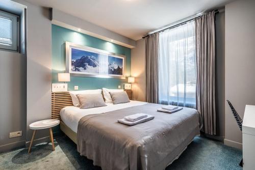 a bedroom with a large bed and a window at Eden Hotel, Apartments and Chalet Chamonix Les Praz in Chamonix-Mont-Blanc