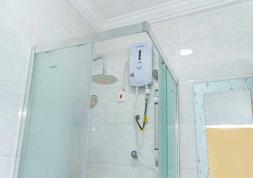 La salle de bains est pourvue d'une douche avec une porte en verre. dans l'établissement La-VIV ROYAL HOTEL, à Kumasi