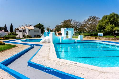 a swimming pool with a slide in a resort at The Blue House, Pedras D'el Rei, Tavira in Tavira