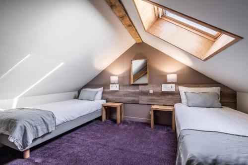 a attic bedroom with two beds and a skylight at Eden Hotel, Apartments and Chalet Chamonix Les Praz in Chamonix-Mont-Blanc
