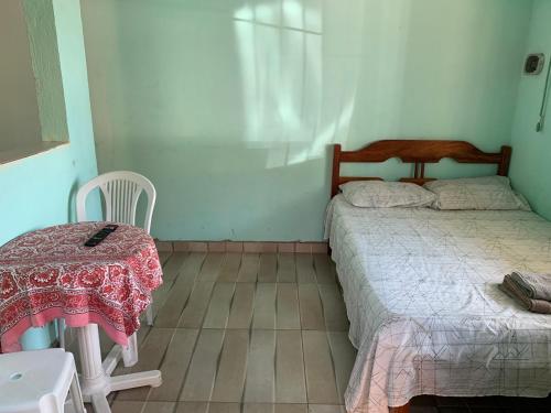 a bedroom with two beds and a table and chair at Pousadinha da Lulu - Pontal Mangue Seco in Indiaroba