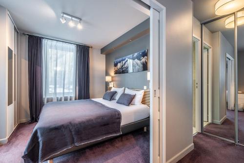 a bedroom with a large bed and a large window at Eden Hotel, Apartments and Chalet Chamonix Les Praz in Chamonix-Mont-Blanc