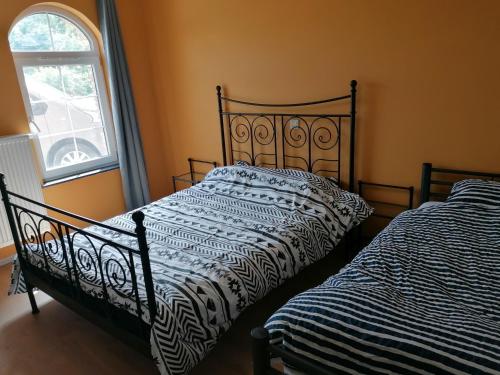 twee bedden naast elkaar in een slaapkamer bij Gîte Savane près de Pairi Daiza in Brugelette