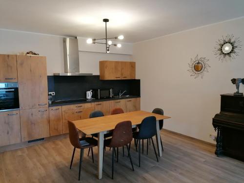 eine Küche mit einem Holztisch und Stühlen in der Unterkunft Gîte Savane près de Pairi Daiza in Brugelette
