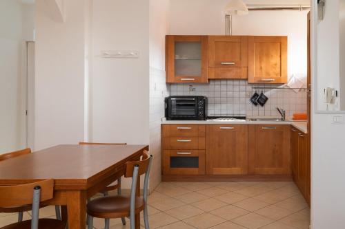 une cuisine avec des placards en bois et une table avec des chaises dans l'établissement Casa in Chiana, à Torrita di Siena