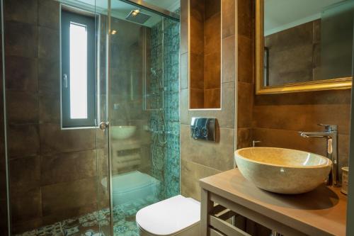 a bathroom with a bowl sink and a shower at Apollonian Luxury Apartments in Vasiliki