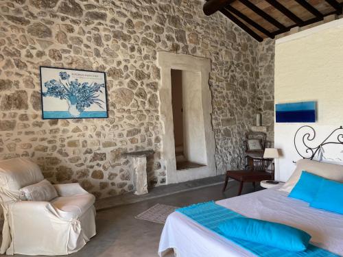 une chambre avec deux lits et un mur en pierre dans l'établissement MAS D ASTRE, à Maussane-les-Alpilles