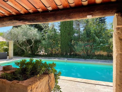 - une piscine dans une cour avec un toit en bois dans l'établissement MAS D ASTRE, à Maussane-les-Alpilles