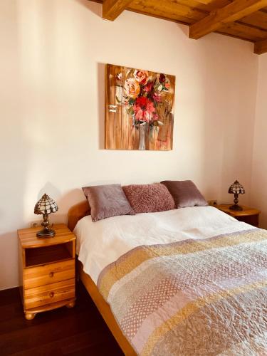 a bedroom with a bed and a painting on the wall at Csigevár Birtok in Balatonendréd