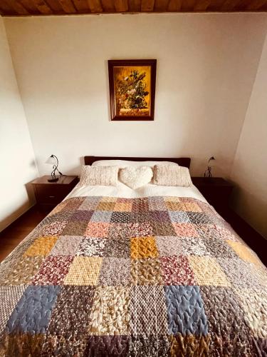 a bedroom with a bed with a quilt on it at Csigevár Birtok in Balatonendréd