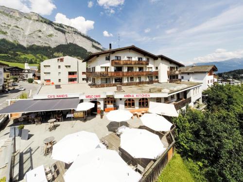 a hotel with umbrellas in front of a building at Arena Lodge in Flims