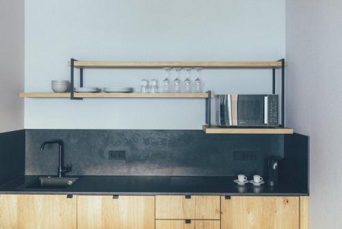 una cucina con piano di lavoro nero e forno a microonde di DAS GERLOS - Boutique Hotel a Gerlos