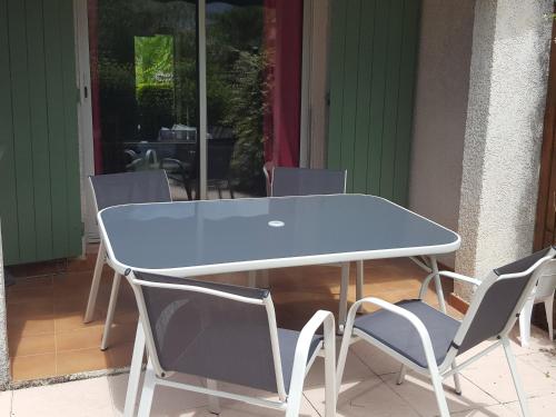 une table et des chaises bleues sur une terrasse dans l'établissement tahiti parc maisonnette 6 pers 2 chambre, au Lavandou