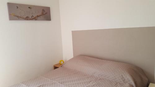 - une chambre avec un lit et une photo sur le mur dans l'établissement tahiti parc maisonnette 6 pers 2 chambre, au Lavandou