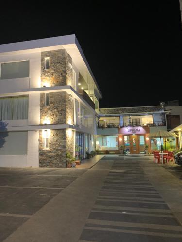 a building with a parking lot in front of it at night at Hotel Shalom in Riobamba