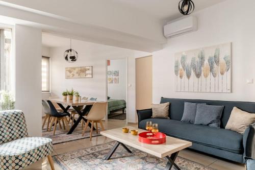 uma sala de estar com um sofá azul e uma mesa em Brand New Bright modern 6bdr apt-1min to Acropolis em Atenas