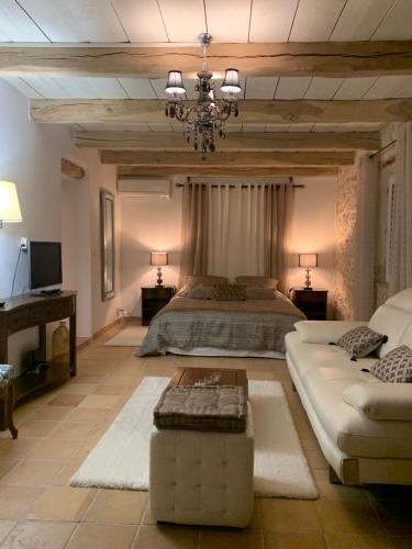 a large bedroom with a bed and a chandelier at le mas des roses 1884 in Vence