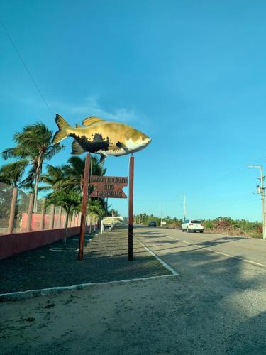 a statue of a fish on top of a sign at Pousadinha da Lulu - Pontal Mangue Seco in Indiaroba