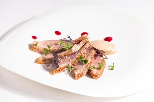 a plate of food with meat on a white plate at Penzion Repnik in Kamnik