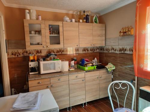 ハイドゥソボスローにあるFenyves Nyaralóのキッチン(木製キャビネット、電子レンジ付)
