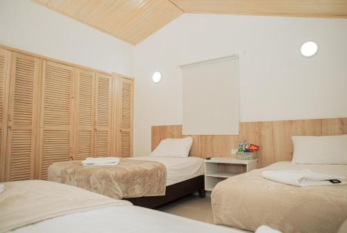 um quarto com 2 camas e persianas de madeira em Casa LOURDES em Valledupar