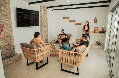 a group of people sitting in chairs in a living room at Casa LOURDES in Valledupar