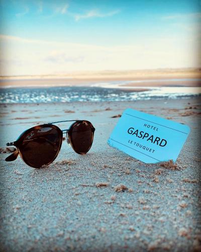 a pair of sunglasses and a sign on the beach at Hôtel Gaspard in Le Touquet-Paris-Plage