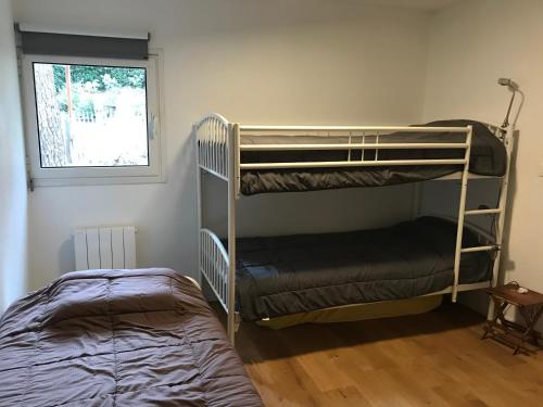 a bedroom with two bunk beds and a window at Maison entre forêt et océan - Lacanau Océan in Lacanau-Océan