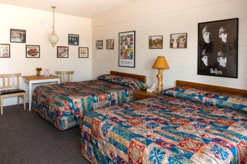 Habitación de hotel con 2 camas y mesa en Grand Canyon Caverns Inn, en Peach Springs