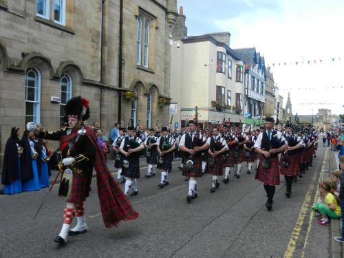 a group of men in kilts marching in a parade at Morangie Hotel Tain in Tain