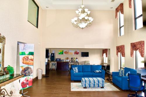 a living room with blue couches and a chandelier at Quality Inn & Suites Pine Bluff in Pine Bluff