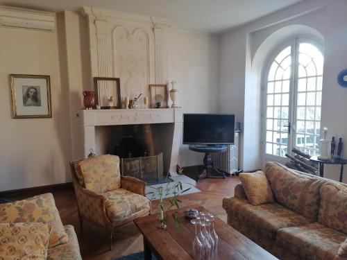 ein Wohnzimmer mit einem Sofa und einem Kamin in der Unterkunft Chambre d hôte de la paix in La Rochefoucauld