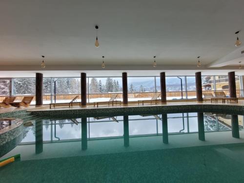 a large indoor pool with tables and benches in a building at 7Soapte in Braşov