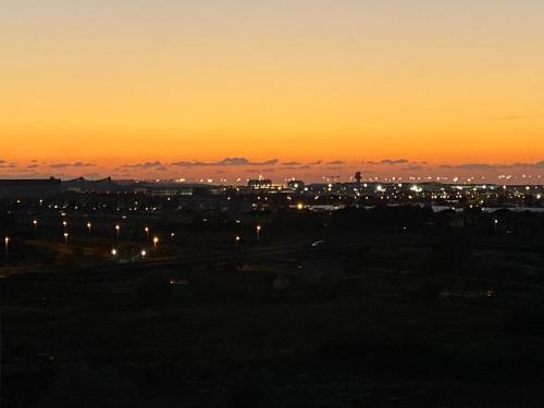 a view of a city at sunset at AGM Suite Rome Airport FCO - Attico Parco Leonardo in Fiumicino