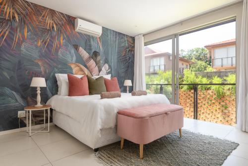 a bedroom with a large bed with a tropical wallpaper at Zimbali Wedge Unit 42 in Ballito