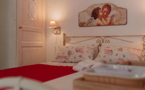 a bedroom with a bed with a picture on the wall at La Casa del Limoneto in Favignana