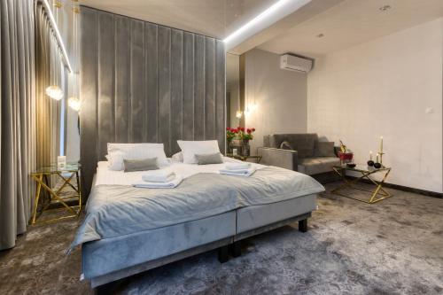 a bedroom with a large bed and a couch at Hotel & Spa Biały Dom in Gliwice