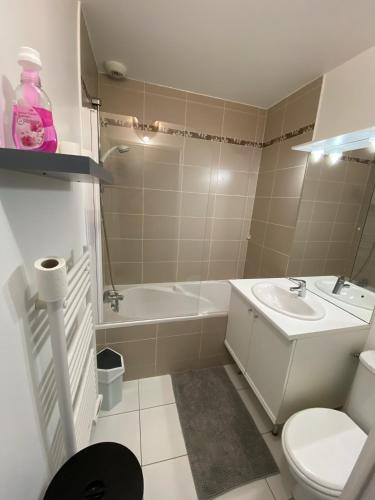une salle de bain avec un lavabo, une baignoire et des toilettes dans l'établissement Maison bord de mer, au calme, 4 personnes, à Riantec