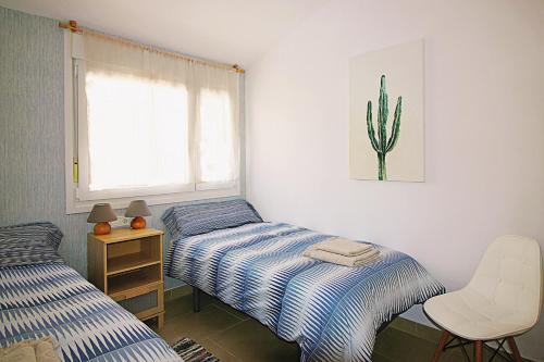 sypialnia z dwoma łóżkami i kaktusem na ścianie w obiekcie Casa Indigo w Almuñécar