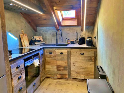 una pequeña cocina con armarios de madera y fregadero en Pleta Tarter. 47G, en El Tarter
