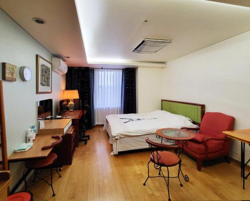 a hotel room with a bed and a desk and chairs at Khan Residence in Seoul