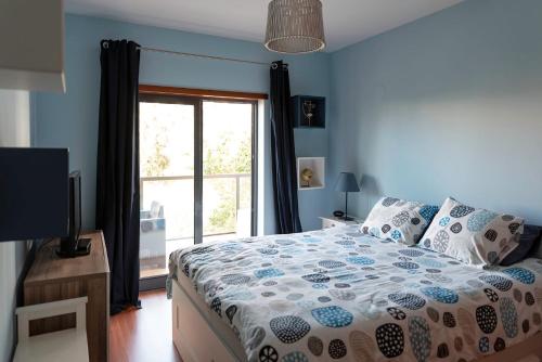 - une chambre bleue avec un lit et une fenêtre dans l'établissement The Cosy VilaRosa near the Beach Portimão, à Portimão