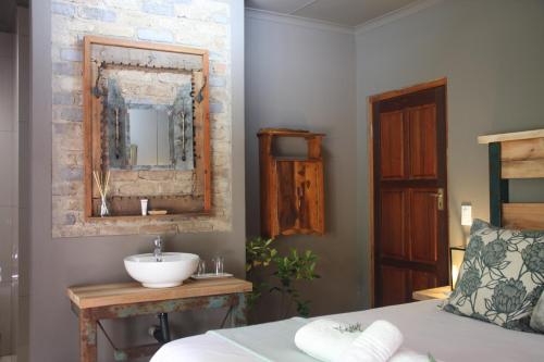 uma casa de banho com um lavatório e um espelho em Green Pascua Bed and Breakfast em Roodepoort